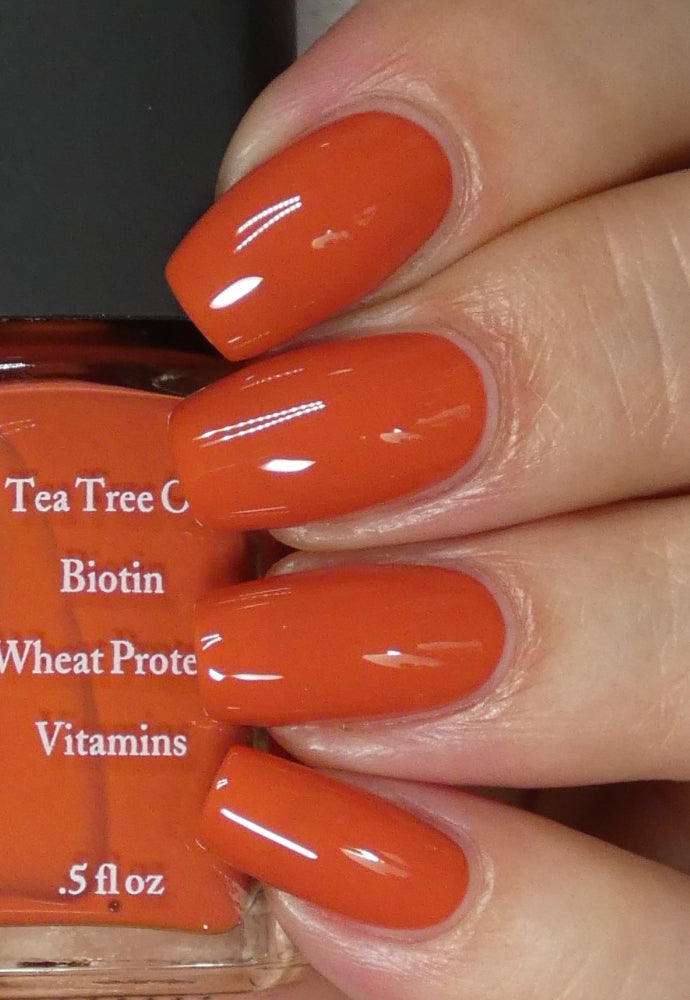 Beautiful nails holding Dr.'s Remedy Enriched Nail Polish in ALTRUISTIC Auburn, a burnt orange shade enriched with Tea Tree Oil, Biotin, and Wheat Protein for healthy nails