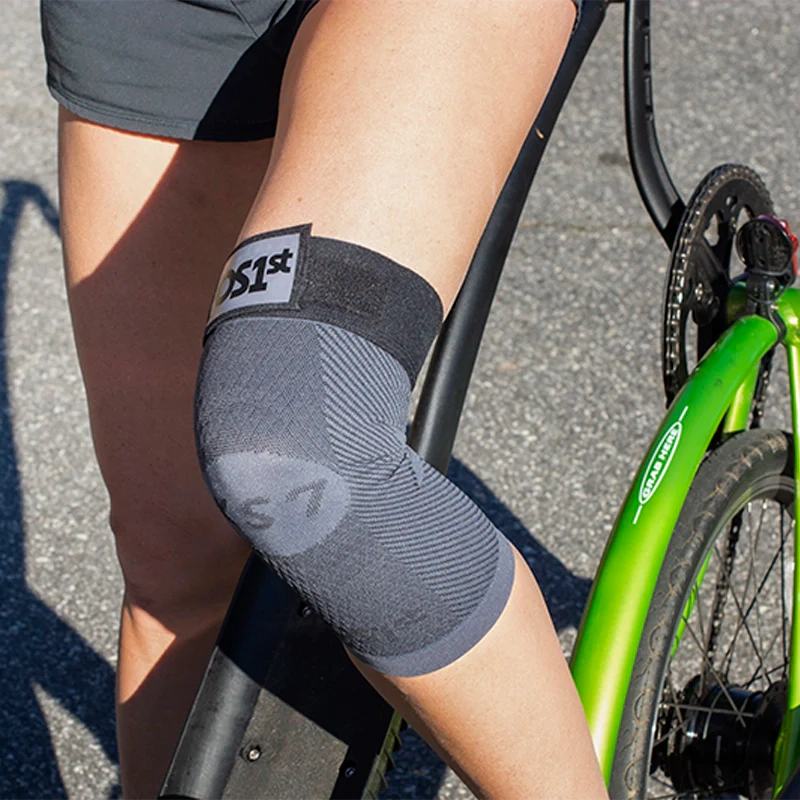 Lady on a bike wearing a OS1st KS7+ Adjustable Performance Knee Sleeve in black, offering targeted compression for knee pain relief and support, designed to improve mobility during activity.