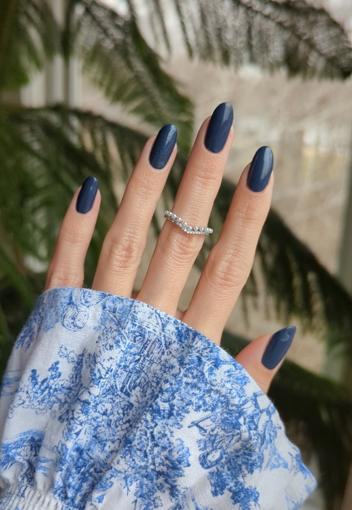 Beautiful nails painted with Dr.'s Remedy Enriched Nail Polish in DEVOTED Denim, a creamy indigo with grey undertones shade, showcasing a glossy finish and complemented by diamond pearl rings