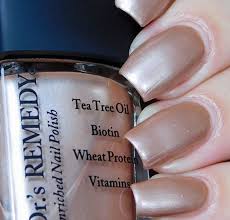 Beautiful nails holding Dr.'s Remedy Enriched Nail Polish in POISED Pink Champagne, a shimmering soft pink champagne shade enriched with Tea Tree Oil, Biotin, and Wheat Protein for healthy nails