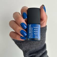 Beautiful nails holding Dr.'s Remedy Enriched Nail Polish in CONFIDENT Cobalt, a deepest ocean blue shade enriched with Tea Tree Oil, Biotin, and Wheat Protein for healthy nails