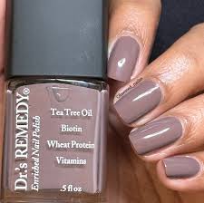 Beautiful nails holding Dr.'s Remedy Enriched Nail Polish in MOTIVATING Mink, a muted mink shade, spiked with subtle purple and cocoa undertones, enriched with Tea Tree Oil, Biotin, and Wheat Protein for healthy nails