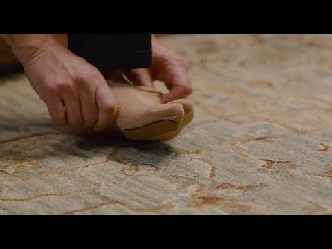 How to wear OS1st TT3 Turf Toe Bracing Sleeve / Hallux Limitus Splint in black, offering targeted compression and support to relieve pain and improve foot alignment for better mobility.