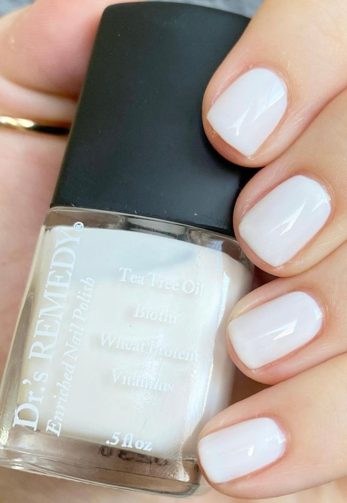 Beautiful nails holding Dr.'s Remedy Enriched Nail Polish in CLASSIC Cloud, a crisp, clean, full coverage white shade enriched with Tea Tree Oil, Biotin, and Wheat Protein for healthy nails