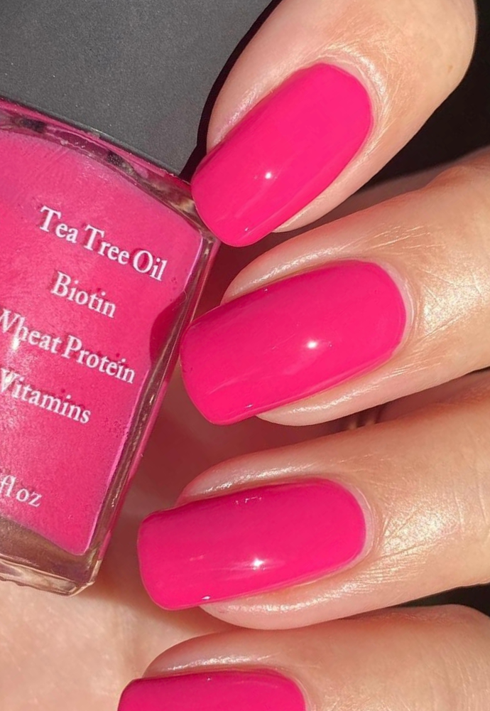 Beautiful nails holding Dr.'s Remedy Enriched Nail Polish in HOPEFUL Hot Pink, a bright pink shade enriched with Tea Tree Oil, Biotin, and Wheat Protein for healthy nails