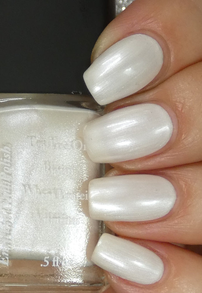 Beautiful nails holding Dr.'s Remedy Enriched Nail Polish in PATIENT Pearl, a snow white hue with soft, reflective, lustrous swirl finish, enriched with Tea Tree Oil, Biotin, and Wheat Protein for healthy nails