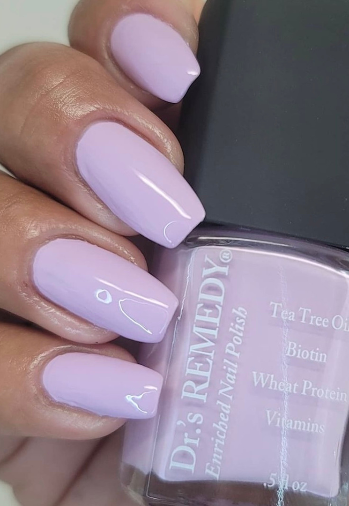 Beautiful nails holding Dr.'s Remedy Enriched Nail Polish in LYRICAL Lilac, a full-coverage pale purple shade with light mauve undertones, enriched with Tea Tree Oil, Biotin, and Wheat Protein for healthy nails